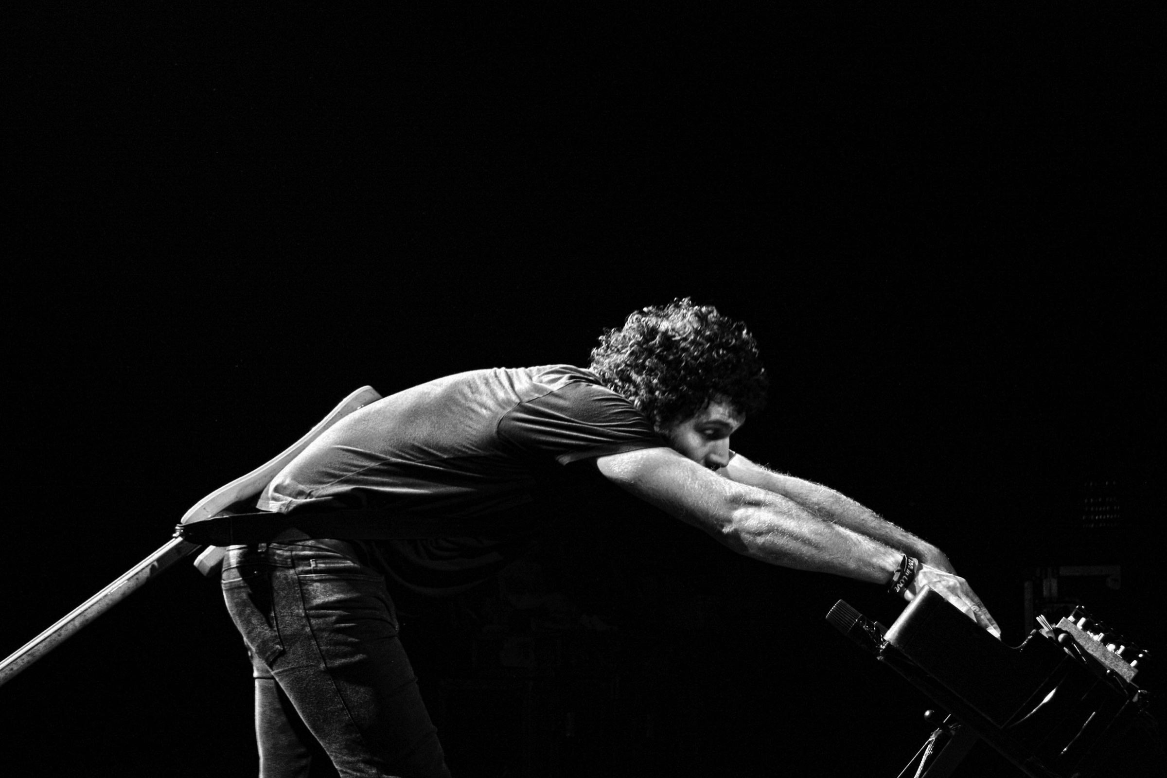 Wolfmother frontman leaning into a live performance